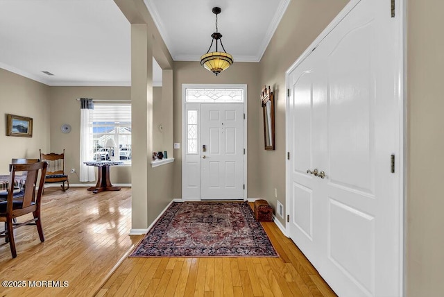 foyer entrance featuring hardwood / wood-style floors and crown molding