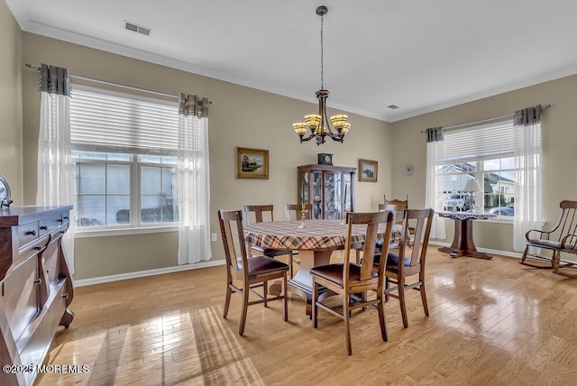 dining room featuring crown molding, a chandelier, and light hardwood / wood-style floors