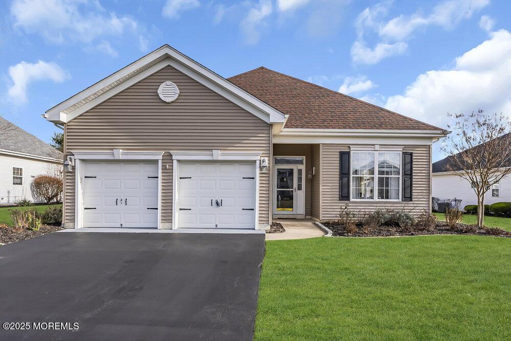 view of front of house with a garage and a front lawn