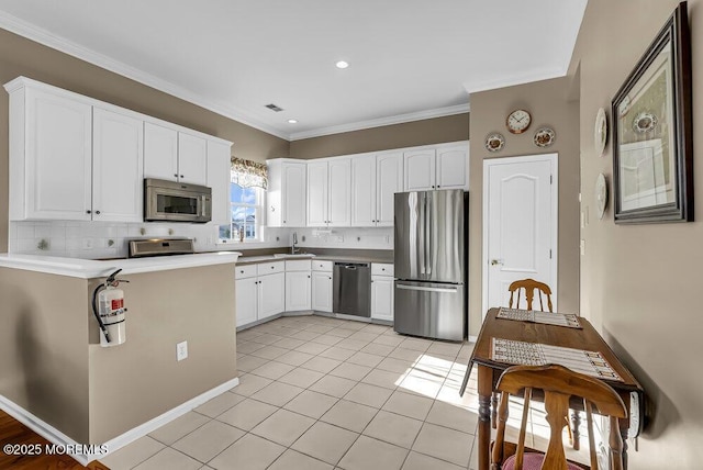 kitchen featuring decorative backsplash, white cabinetry, light tile patterned flooring, and appliances with stainless steel finishes