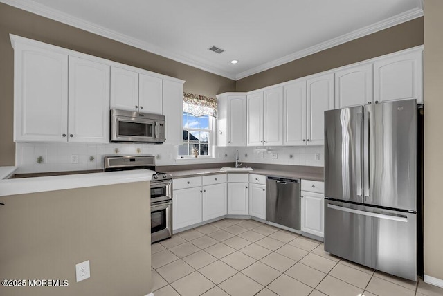 kitchen featuring decorative backsplash, stainless steel appliances, sink, light tile patterned floors, and white cabinets