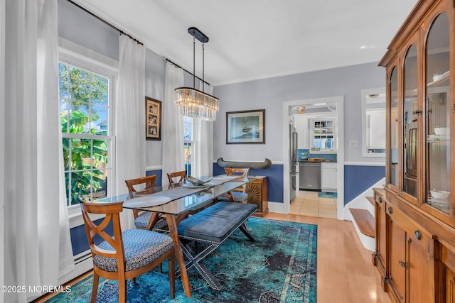 dining space with a notable chandelier and light hardwood / wood-style floors