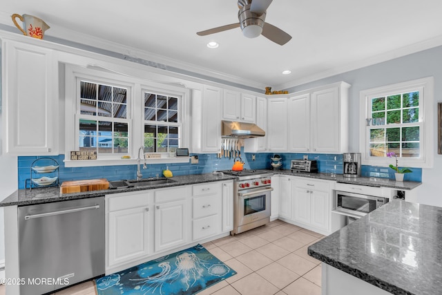 kitchen featuring white cabinets, appliances with stainless steel finishes, sink, ornamental molding, and light tile patterned floors