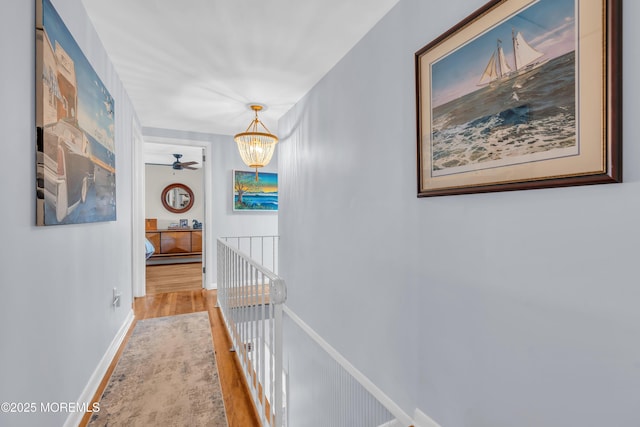 hallway featuring hardwood / wood-style flooring and an inviting chandelier