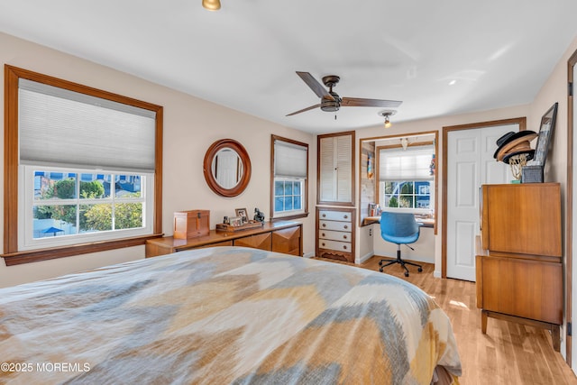 bedroom featuring ceiling fan, multiple windows, and light hardwood / wood-style flooring