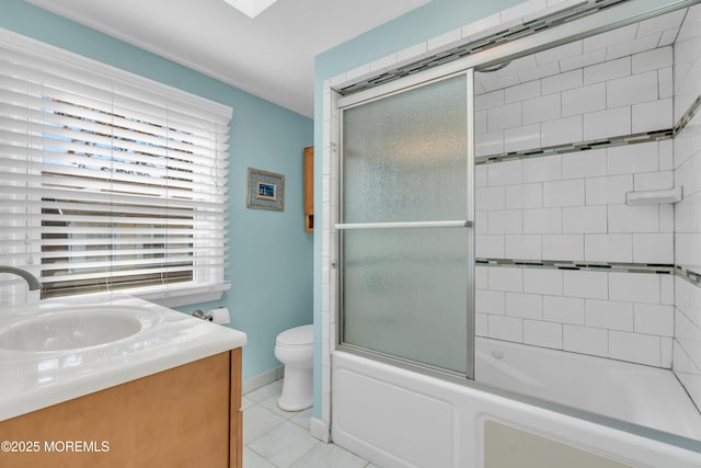 full bathroom with shower / bath combination with glass door, vanity, toilet, and tile patterned flooring