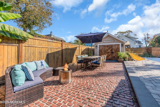 view of patio with an outdoor structure and an outdoor living space with a fire pit