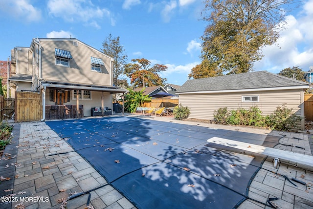 view of pool with a diving board, a patio, and exterior bar