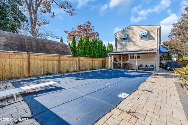 view of pool featuring a diving board and a patio