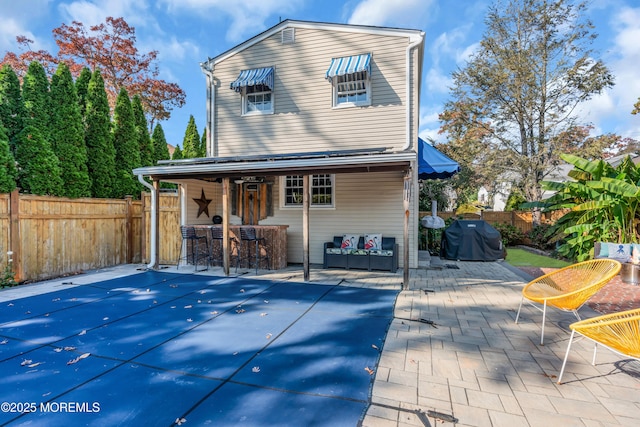 back of house featuring an outdoor bar and a patio