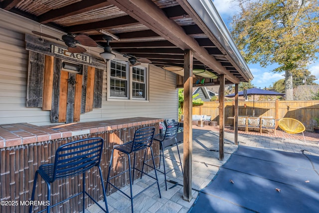 view of patio / terrace featuring an outdoor bar and ceiling fan