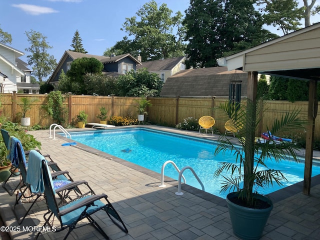 view of swimming pool with a diving board and a patio