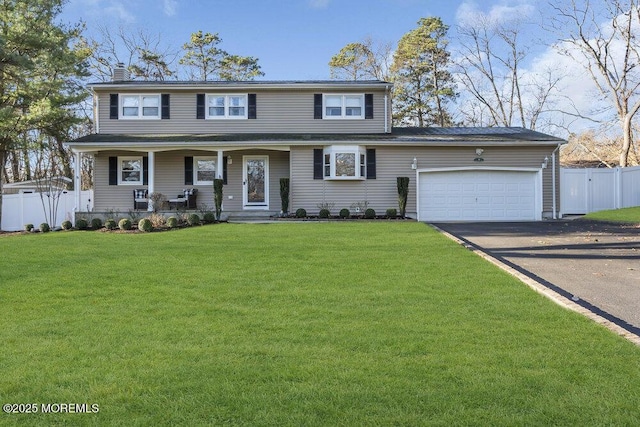 view of front of property featuring covered porch, a garage, and a front lawn