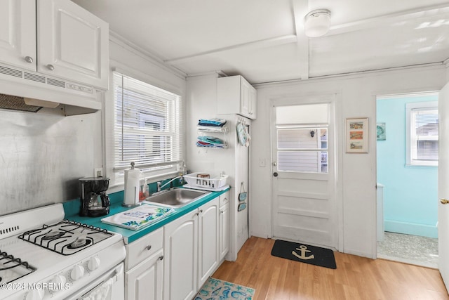 kitchen with white cabinets, white range with gas stovetop, sink, and a wealth of natural light