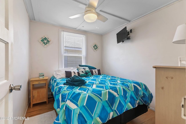 bedroom featuring light hardwood / wood-style floors, ceiling fan, and crown molding