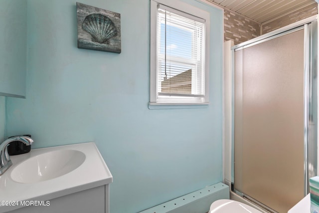 bathroom with toilet, an enclosed shower, and vanity