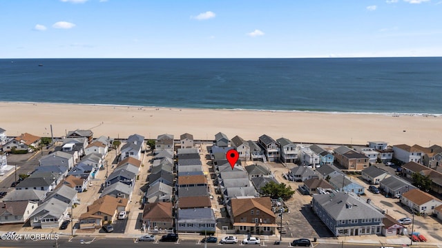 bird's eye view featuring a water view and a beach view