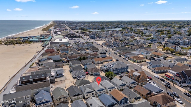 drone / aerial view featuring a water view and a view of the beach