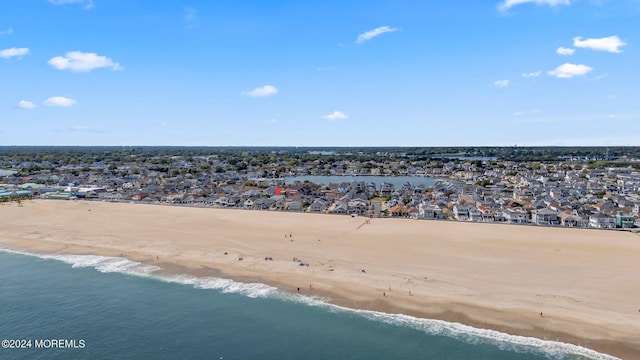 birds eye view of property featuring a beach view and a water view