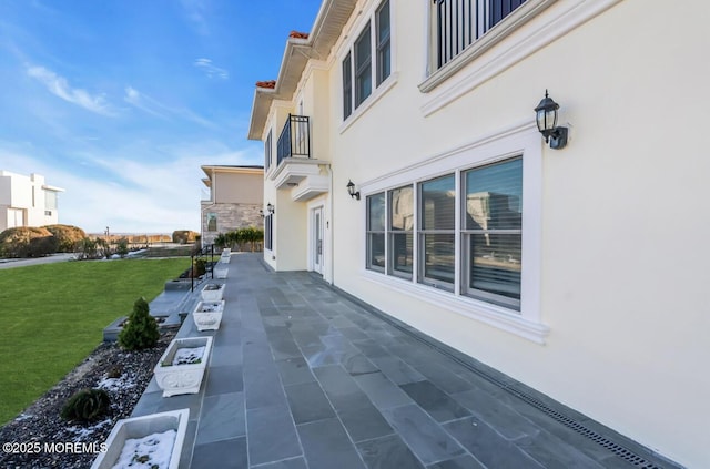 view of property exterior featuring a patio area and a lawn