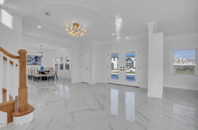 entrance foyer featuring french doors, plenty of natural light, ornamental molding, and a notable chandelier