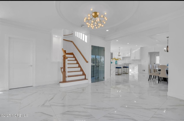 unfurnished living room with ornamental molding, a tray ceiling, and a chandelier