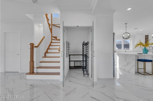 stairway with ornamental molding and a chandelier