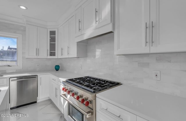 kitchen with backsplash, white cabinets, and appliances with stainless steel finishes