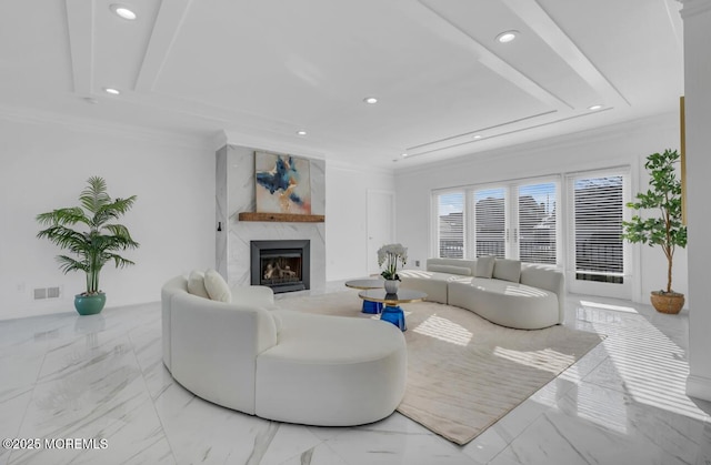 living room with a raised ceiling, crown molding, and a fireplace