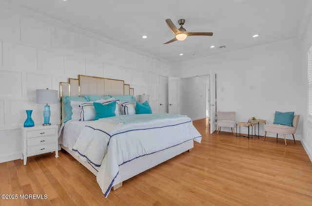 bedroom featuring ornamental molding, ceiling fan, and light wood-type flooring