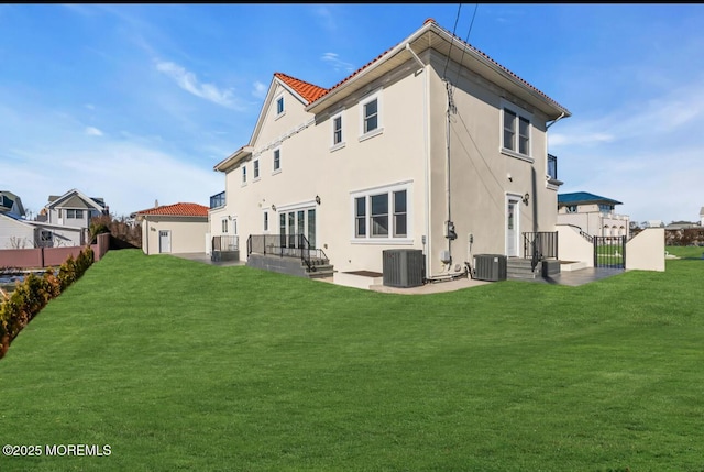 rear view of property featuring a yard and central air condition unit