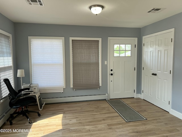 entryway with light hardwood / wood-style floors and baseboard heating