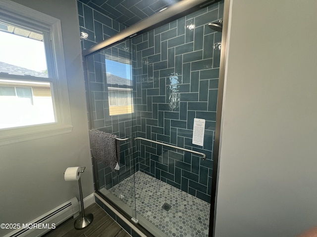 bathroom featuring baseboard heating and a shower with shower door