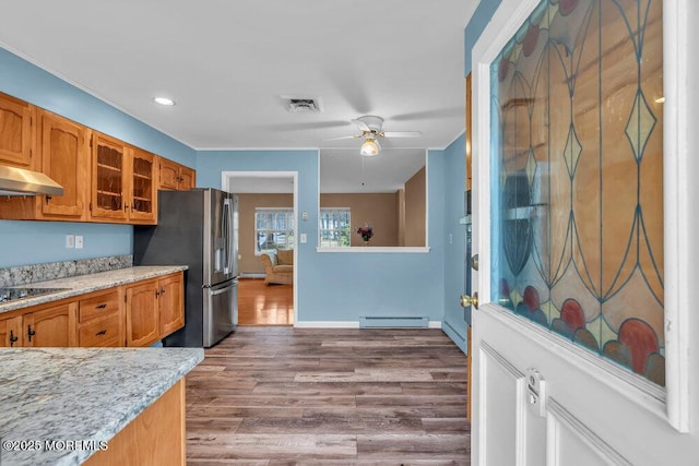 kitchen with ceiling fan, a baseboard radiator, stainless steel refrigerator with ice dispenser, extractor fan, and wood-type flooring