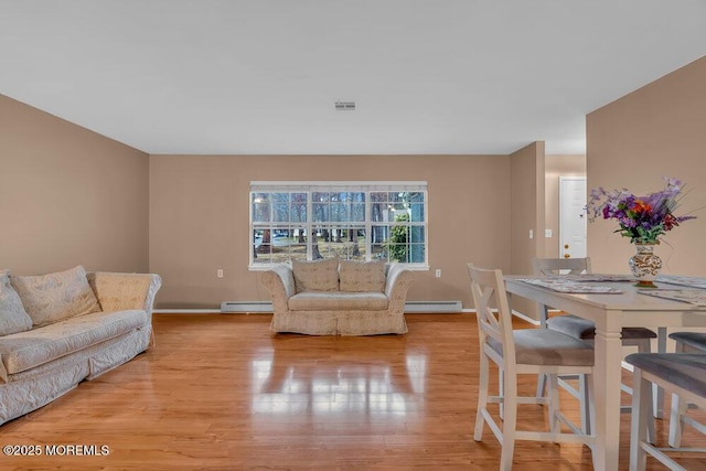 living room featuring light wood-type flooring and baseboard heating