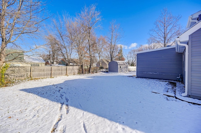 yard covered in snow with a shed