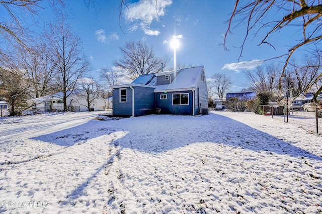 snow covered back of property with central AC unit