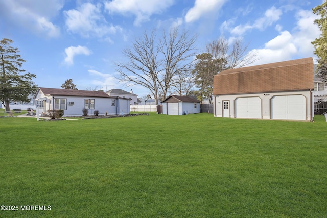 view of yard featuring a garage and an outdoor structure