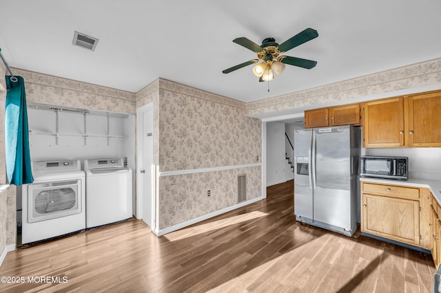 kitchen with ceiling fan, independent washer and dryer, light wood-type flooring, and stainless steel fridge with ice dispenser