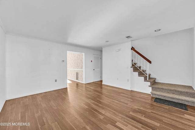 unfurnished living room with hardwood / wood-style floors and ornamental molding