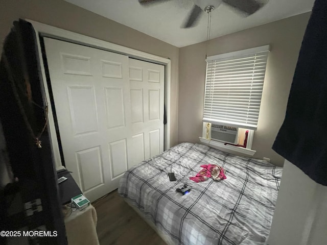 bedroom with ceiling fan, cooling unit, wood-type flooring, and a closet