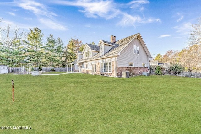 rear view of property with a yard and central AC unit