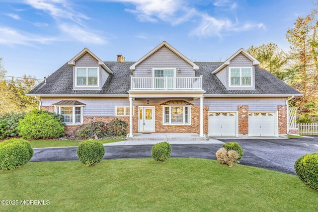 view of front of house with a balcony, a garage, and a front lawn