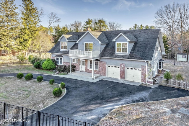 view of front of property featuring a balcony and a garage