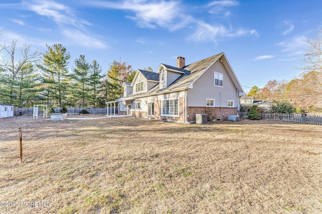 back of house featuring a yard and central AC