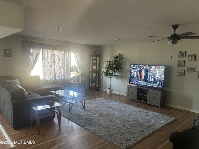 living room featuring ceiling fan and dark hardwood / wood-style floors