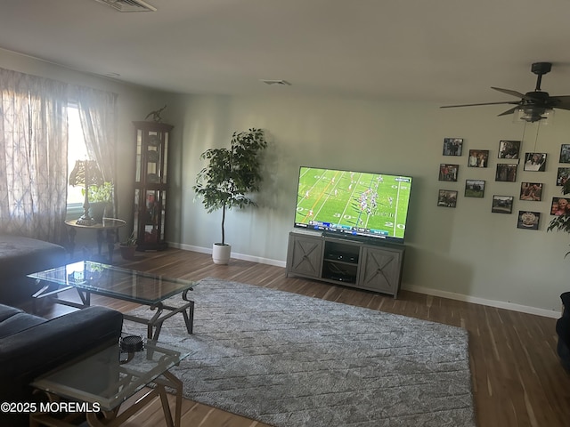 living room featuring ceiling fan and dark wood-type flooring