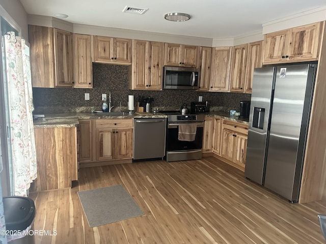 kitchen featuring light stone countertops, decorative backsplash, stainless steel appliances, dark wood-type flooring, and sink