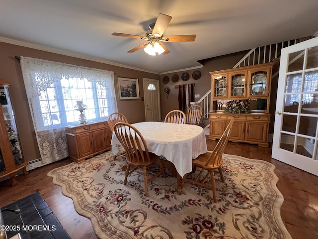 dining room featuring a baseboard heating unit, dark hardwood / wood-style floors, ceiling fan, and ornamental molding