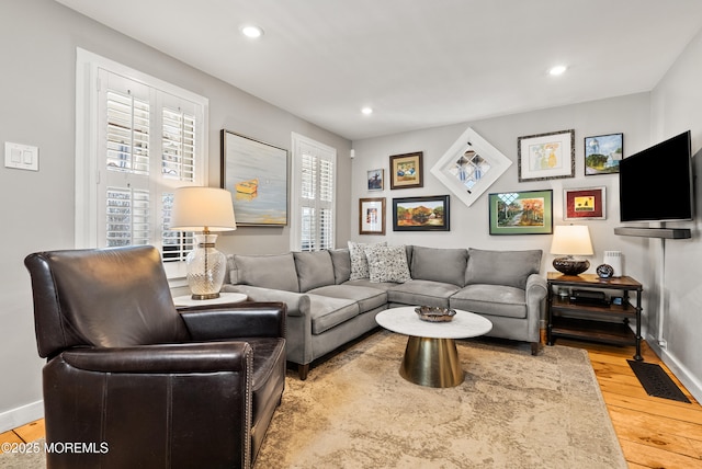 living area featuring light wood-style floors, recessed lighting, visible vents, and baseboards